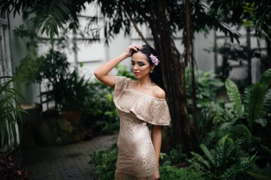 Genç ve güzel bir esmer, sık orman ve yağmur ormanları arasında poz veriyor. Spa