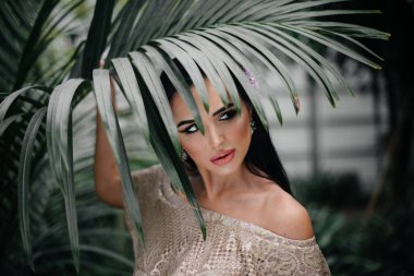 Genç ve güzel bir esmer, sık orman ve yağmur ormanları arasında poz veriyor. Spa