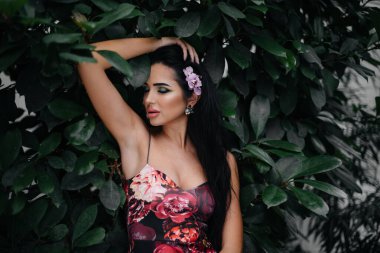 Genç ve güzel bir esmer, sık orman ve yağmur ormanları arasında poz veriyor. Spa