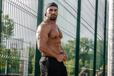 Spor sahasında üstsüz poz veren seksi fitness sporcusu. Fitness, vücut geliştirme, sağlıklı yaşam tarzı