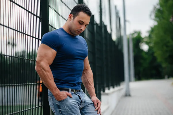 Sporcu çocuk spor sahasının yanında duruyor. Vücut geliştirme