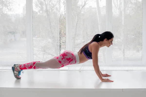 Atletisch Jong Meisje Voert Oefeningen Studio Een Lichte Achtergrond Fitness — Stockfoto