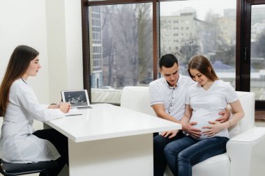 A young couple waiting for a baby to consult a gynecologist after an ultrasound. Pregnancy, and health care clipart