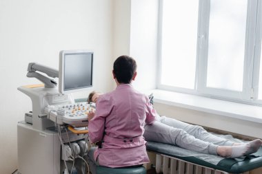 Hamile bir kız klinikte karnının ultrasonuna giriyor. Tıbbi muayene