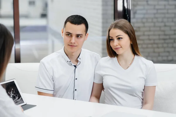 A young couple at a gynecologist\'s consultation after an ultrasound. Pregnancy, and health care