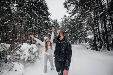 Ormanda karla oynayan çift.