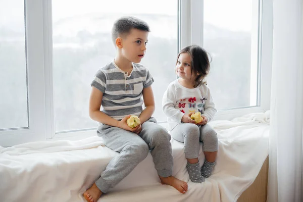 Irmão Irmã Estão Sentados Peitoril Janela Brincando Comendo Maçãs Felicidade — Fotografia de Stock