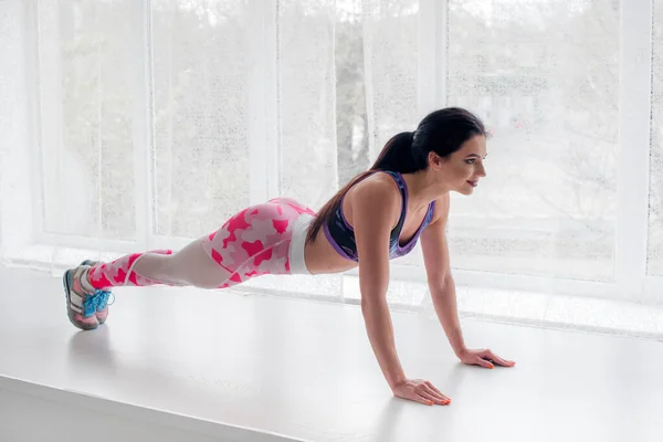 Chica Joven Atlética Realiza Ejercicios Estudio Sobre Fondo Claro Fitness —  Fotos de Stock