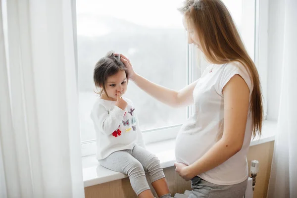 Uma Mãe Grávida Está Parada Perto Janela Com Sua Filhinha — Fotografia de Stock