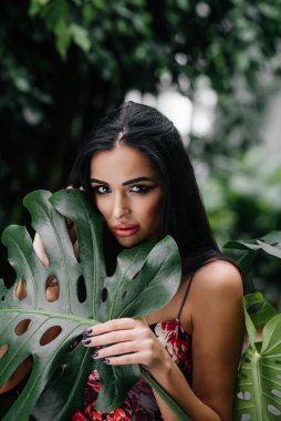 Genç ve güzel bir esmer, sık orman ve yağmur ormanları arasında poz veriyor. Spa