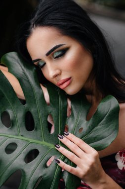 Genç ve güzel bir esmer, sık orman ve yağmur ormanları arasında poz veriyor. Spa