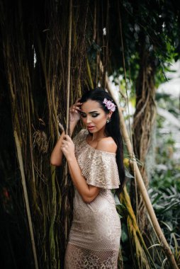 Genç ve güzel bir esmer, sık orman ve yağmur ormanları arasında poz veriyor. Spa