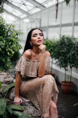Genç ve güzel bir esmer, sık orman ve yağmur ormanları arasında poz veriyor. Spa