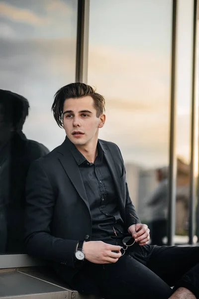 日没時には鏡のような建物の近くにスタイリッシュな若い男が立っている ファッション — ストック写真