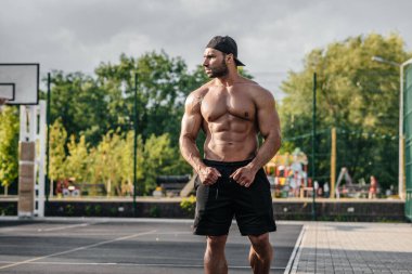 Spor sahasında üstsüz poz veren seksi fitness sporcusu. Fitness, vücut geliştirme, sağlıklı yaşam tarzı