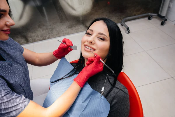 歯医者はその少女の歯を患者に治療する — ストック写真