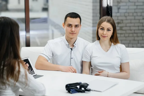 A young couple at a gynecologist\'s consultation after an ultrasound. Pregnancy, and health care