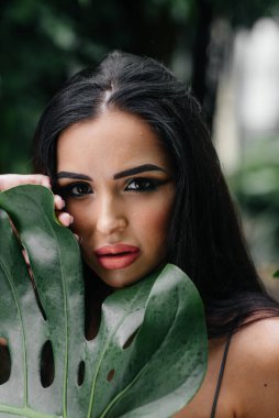 Genç ve güzel bir esmer, sık orman ve yağmur ormanları arasında poz veriyor. Spa