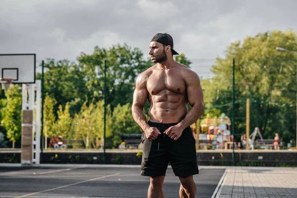 Spor sahasında üstsüz poz veren seksi fitness sporcusu. Fitness, vücut geliştirme, sağlıklı yaşam tarzı