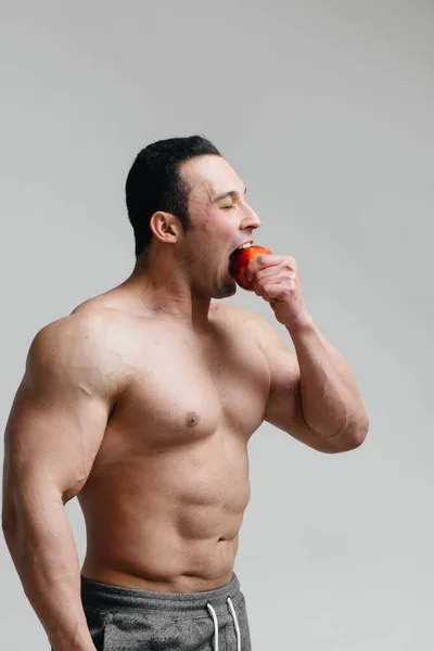 在白色背景下吃水果的性感小伙 健康饮食 — 图库照片