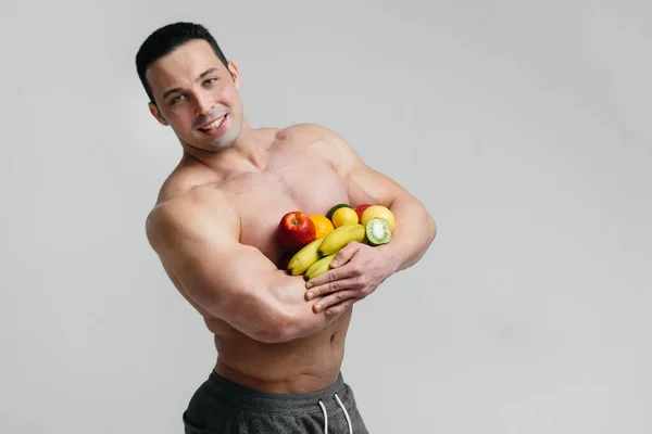 Sportieve Sexy Man Poseren Een Witte Achtergrond Met Helder Fruit — Stockfoto