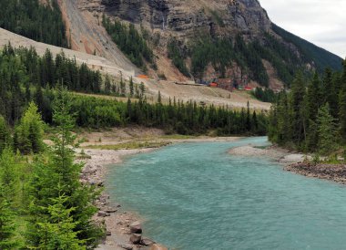 Turkuaz Tekmeleyen At Nehri 'nin ve kıyı şeridinin yukarısındaki demiryolunun manzarası