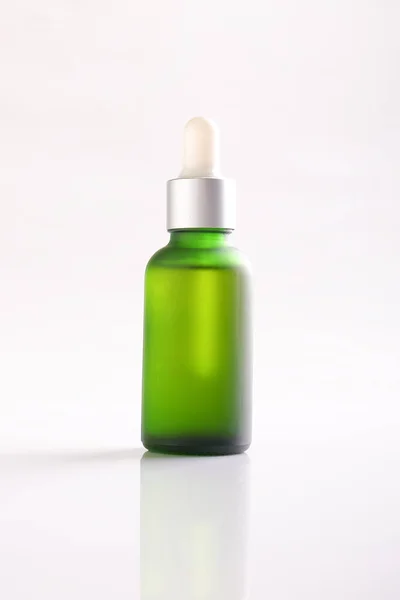 Green essential oil bottle on white background. — Stock Photo, Image