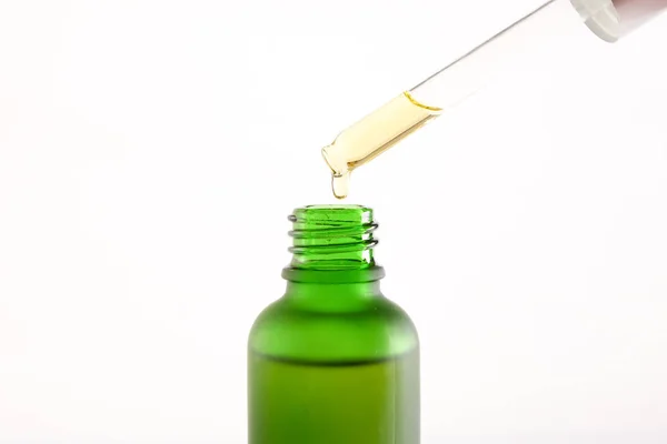 Green essential oil bottle on white background. — Stock Photo, Image