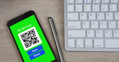 Ahşap masa Qr kodu ekranda gösterilen Smartphone.