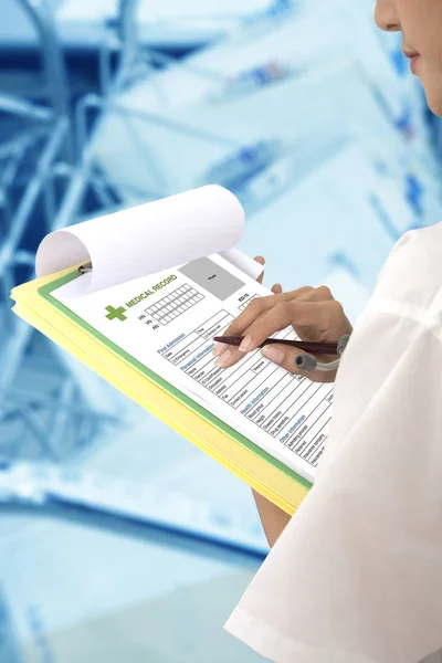 Female doctor holding medical record on clipboard in hand. — Stock Photo, Image
