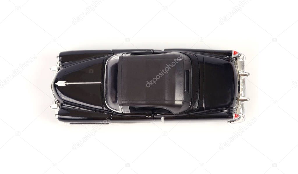 Top view of toy model classic car on white background.