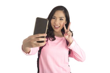 Pembe t-shirt selfie ph alarak sırt çantası ile sevimli turist kız