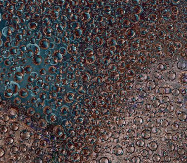 Rastgele dokunmuş halkalar ve farklı çaplarda toplar ve turkuaz, kahverengi ve bakır renkler karışık bir arkaplanda. Soyut fantezi.