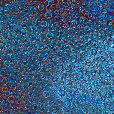 Değişik çaplarda gelişigüzel örülmüş halkalar, toplar ve karışık bir arkaplanda mavi ve kahverengi renkler. Soyut fantezi.