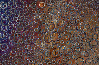 Şablon. Mavi, gri, siyah ve kahverengi halkalar rastgele olarak çok renkli arka planda yer alır. Soyut fantezi. 