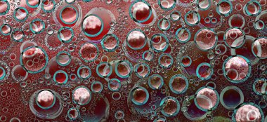 Beyaz ve mavi halkalar ve mavi haleli farklı çaplı kırmızı küreler çok renkli bir arka planda yer almaktadır. Boşluk soyutlaması. 