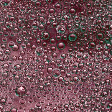 Yeşil haleli, bordo renginde küreler ve yansımaları bordo bir arka planda yer alıyor. Kozmik soyutlama.