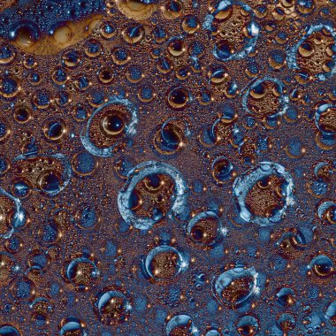 Büyük açık mavi yüzükler ve siyah küreler altın arka planda yer almaktadır. Kozmik soyutlama. 