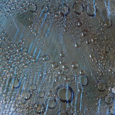 Doku. Açık açık kahverengi zemin üzerinde yağmur damlaları ve akan yağmur damlaları mavi siluetleri yer almaktadır. Soyut fantezi.