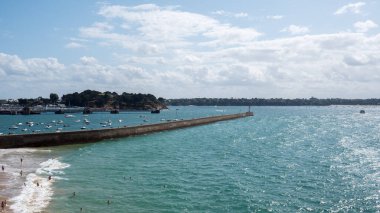 Saint Malo deniz fenerinin güzel iskelesi, Fransa 17-9-19. Yeşil deniz, mavi gökyüzü, yüzen insanlar ve arka planda tekneler.