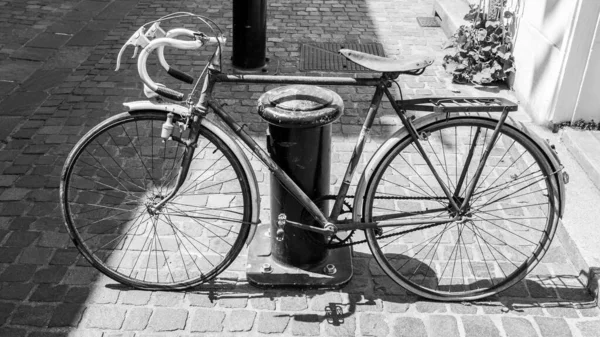 Svart och vitt skott av gammal fransk stil rostig cykel — Stockfoto