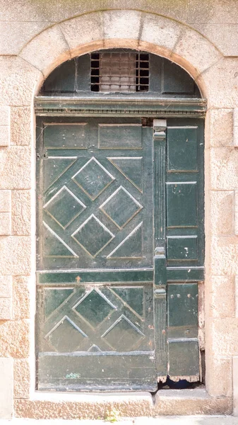 green Painted wooden door in Saint Malo, France 17-9-19, two piece made, with half circle up part, very typical