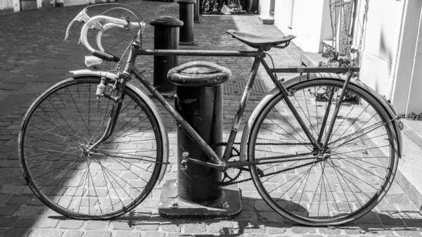 Black and white shot of old french style rusty bike frame on paved road — Stock Photo, Image