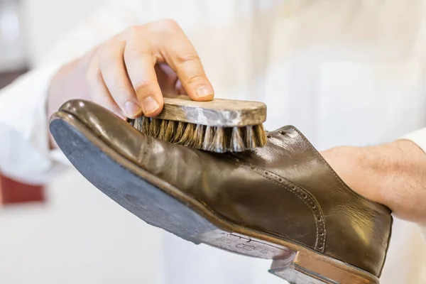 Man body and hand restoring parisian brown leather shoes. White shirt with old traditional brush — Stock Photo, Image
