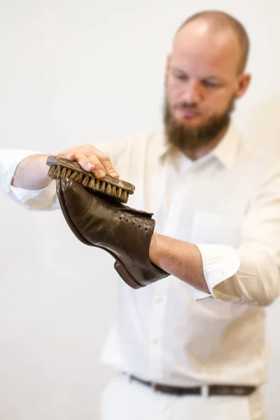 Beau homme avec des chaussures de polissage de barbe, ce fabricant de chaussures restaure de belles vieilles chaussures . — Photo