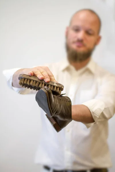 Shoe maker restoring beautiful old shoes. wearing white shirt. blurred background. — 图库照片