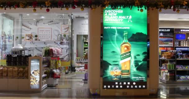 Покупатели и продавцы в магазине беспошлинной торговли в тайваньском городе Таоюйдао любят покупать там алкоголь, кетчупы или продукты из кожи. Путешествующий снимок с точкой резки и отслеживания . — стоковое видео