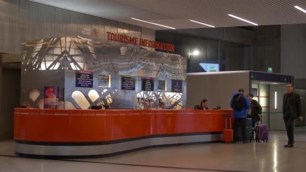 ดาดฟ้าข้อมูลการท่องเที่ยวในสนามบิน Charles de Gaulle, ปารีส, ฝรั่งเศส, 5.2.2020 นักท่องเที่ยวมักจะท่วมท้นไปด้วยข้อมูลและตัวเลือกเมื่อพวกเขามาถึงที่ปลายทางใหม่ . — วีดีโอสต็อก