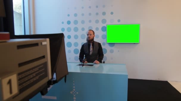 Handsome serious caucasian man adult with beard talking and interviewing on tv news event. professional television camera with green screen in background (inlay possibility) — Stock Video