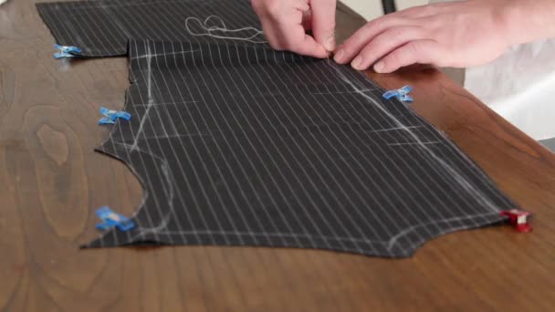 裁缝店女裁缝的手，用粗麻线缝制一件意大利裁剪毛织物的夹克。这个裁缝在车间里手工缝制布料。近身4K — 图库视频影像
